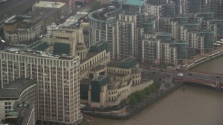 AX115_063 - 5.5K aerial stock footage of orbiting MI6 Building in the rain, London, England