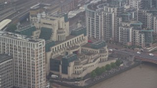 AX115_063E - 5.5K aerial stock footage of MI6 Building in the rain, London, England