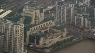 AX115_064 - 5.5K aerial stock footage of orbiting MI6 Building in the rain, London, England