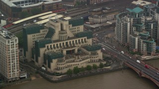 AX115_065 - 5.5K aerial stock footage of orbiting the MI6 Building in the rain, London, England
