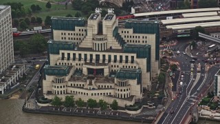 AX115_065E - 5.5K aerial stock footage of orbiting the MI6 Building in the rain, London, England