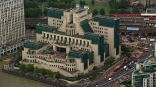 AX115_068 - 5.5K aerial stock footage of an orbit of the MI6 Building in the rain, London, England