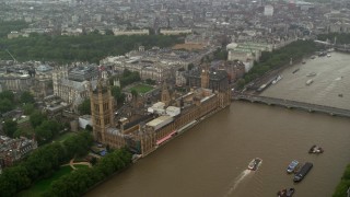 AX115_073 - 5.5K aerial stock footage approach Big Ben and Parliament from the river in the rain, London, England