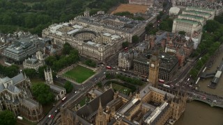 AX115_074 - 5.5K aerial stock footage fly over Big Ben and Parliament toward Treasury and Foreign Office in the rain, London, England