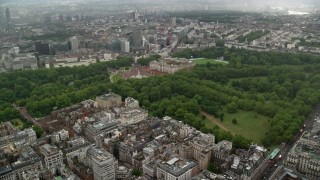 AX115_078 - 5.5K stock footage aerial video approach Buckingham Palace from office buildings in the rain, London, England
