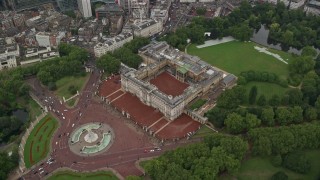 AX115_078E - 5.5K aerial stock footage tilt to bird's eye of Buckingham Palace in the rain, London, England