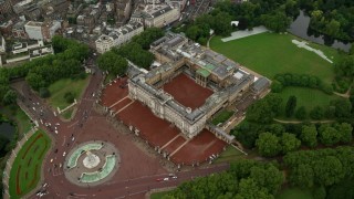 AX115_080 - 5.5K stock footage aerial video tilt to bird's eye of Buckingham Palace in the rain, London, England