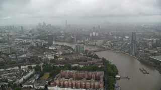 AX115_083 - 5.5K aerial stock footage of River Thames winding through the city while raining, London, England
