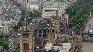 AX115_105 - 5.5K stock footage aerial video of British flag on Parliament near Big Ben, London, England