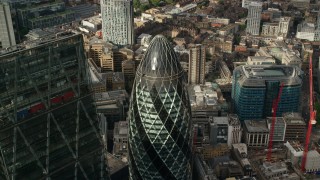 AX115_190 - 5.5K aerial stock footage tilt to the top of The Gherkin during approach, Central London, England