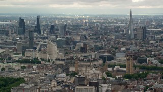 AX115_267 - 5.5K stock footage aerial video the London Eye and Parliament, with skyscrapers in the background, England