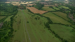 AX115_303 - 5.5K aerial stock footage fly over country road and farmland, Coulsdon, England