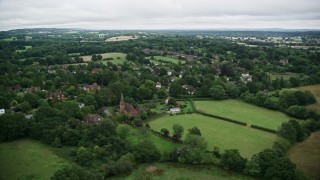 AX115_317E - 5.5K aerial stock footage orbiting homes in a rural village, Redhill, England