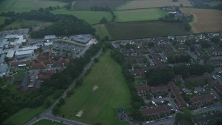AX116_001 - 5.5K aerial stock footage of flying by homes, East Surrey Hospital, Redhill, England, twilight