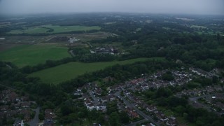 AX116_002E - 5.5K aerial stock footage of flying by homes in Redhill, England, twilight