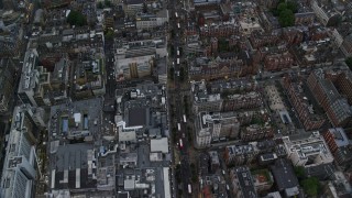 AX116_050E - 5.5K aerial stock footage of flying over Oxford Street with double decker buses, London, England, twilight