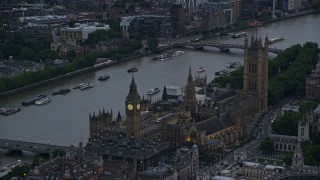 AX116_059E - 5.5K aerial stock footage of flying by Big Ben and British Parliament on River Thames, London, England, twilight