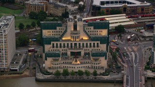 AX116_066 - 5.5K aerial stock footage of the MI6 Building by the River Thames, London, England, twilight