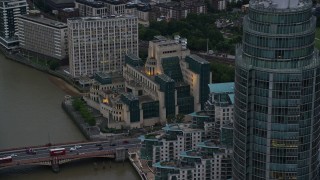 AX116_069 - 5.5K aerial stock footage of flying by MI6 Building and St George Wharf Tower, London, England, twilight