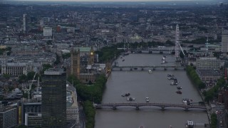 AX116_070E - 5.5K aerial stock footage of Big Ben, London Eye and bridges spanning the River Thames, London, England, twilight
