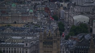 AX116_072 - 5.5K aerial stock footage of the British Flag atop the British Parliament, London, England, twilight