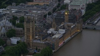 AX116_073E - 5.5K aerial stock footage of approaching Big Ben and British Parliament from River Thames, London, England, twilight