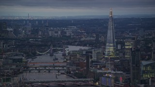 AX116_103E - 5.5K aerial stock footage of Tower Bridge spanning River Thames near The Shard, London, England, night