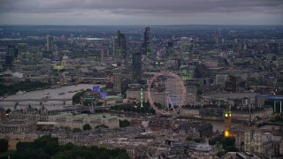 AX116_116 - 5.5K stock footage aerial video of vast cityscape seen from London Eye and Big Ben by River Thames, London, England, night