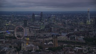 AX116_118 - 5.5K stock footage aerial video passing London Eye, Big Ben and British Parliament by River Thames, London, England, night