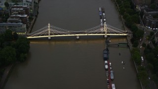 AX116_120E - 5.5K aerial stock footage of approaching Albert Bridge spanning the River Thames, London, England, night