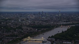 AX116_130E - 5.5K aerial stock footage wide view of London cityscape and River Thames seen from Albert Bridge, London, England, night