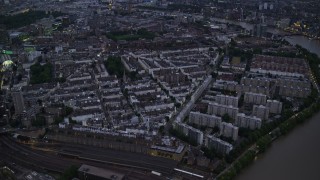AX116_137E - 5.5K aerial stock footage tilt from Chelsea Bridge and River Thames to reveal apartments and cityscape, London, England, night
