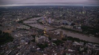 AX116_141 - 5.5K stock footage aerial video fly toward Big Ben, British Parliament, London Eye, and Westminster Abbey, London, England, night