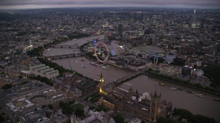 AX116_142 - 5.5K stock footage aerial video of fly over Big Ben, British Parliament and Westminster Abbey toward London Eye, England, night