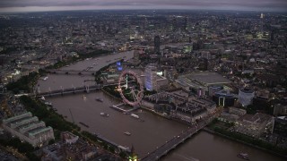 AX116_143 - 5.5K stock footage aerial video of flying over Big Ben toward London Eye and River Thames, London, England, night