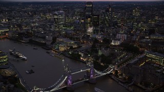AX116_158 - 5.5K aerial stock footage of Tower Bridge and River Thames near Tower of London and skyscrapers, England, night