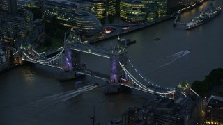 AX116_160 - 5.5K stock footage aerial video of flying by Tower Bridge spanning River Thames in London, England, night