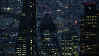 AX116_163 - 5.5K stock footage aerial video of orbiting the top of The Gherkin skyscraper in London, England, night