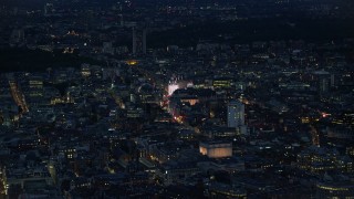 AX116_176 - 5.5K aerial stock footage of flying over city buildings to approach Piccadilly Circus, London, England, night