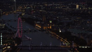 AX116_177 - 5.5K stock footage aerial video flyby London Eye, Big Ben and Parliament, River Thames bridges, London, England, night