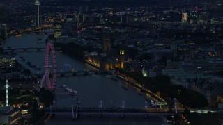 AX116_177E - 5.5K aerial stock footage flyby London Eye, Big Ben and Parliament, River Thames bridges, London, England, night
