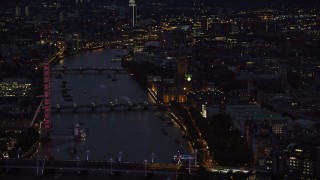 AX116_178 - 5.5K stock footage aerial video passing by London Eye, Big Ben and Parliament, and River Thames bridges, London, England, night