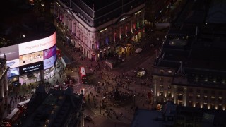 AX116_184 - 5.5K aerial stock footage orbit crowds and double decker buses at Piccadilly Circus, London, England, night