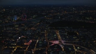 AX116_188 - 5.5K stock footage aerial video fly past Piccadilly Circus, with a view of London Eye and Big Ben, London, England, night