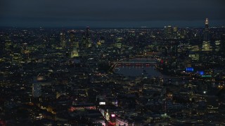 AX116_190E - 5.5K aerial stock footage of passing cityscape, London Eye and Big Ben by River Thames, London, England, night