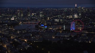 AX116_192 - 5.5K stock footage aerial video flyby skyscrapers and the London Eye by River Thames, London, England, night