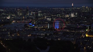 AX116_193 - 5.5K stock footage aerial video of passing cityscape, London Eye and Big Ben by River Thames, London, England, night