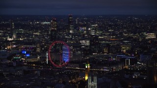 AX116_195 - 5.5K stock footage aerial video of the London Eye, Big Ben and distant skyscrapers, London, England, night
