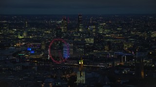 AX116_195E - 5.5K aerial stock footage of the London Eye, Big Ben and distant skyscrapers, London, England, night