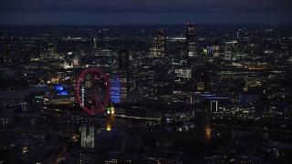AX116_196 - 5.5K stock footage aerial video of London Eye, Big Ben and skyscrapers in the background, London, England, night